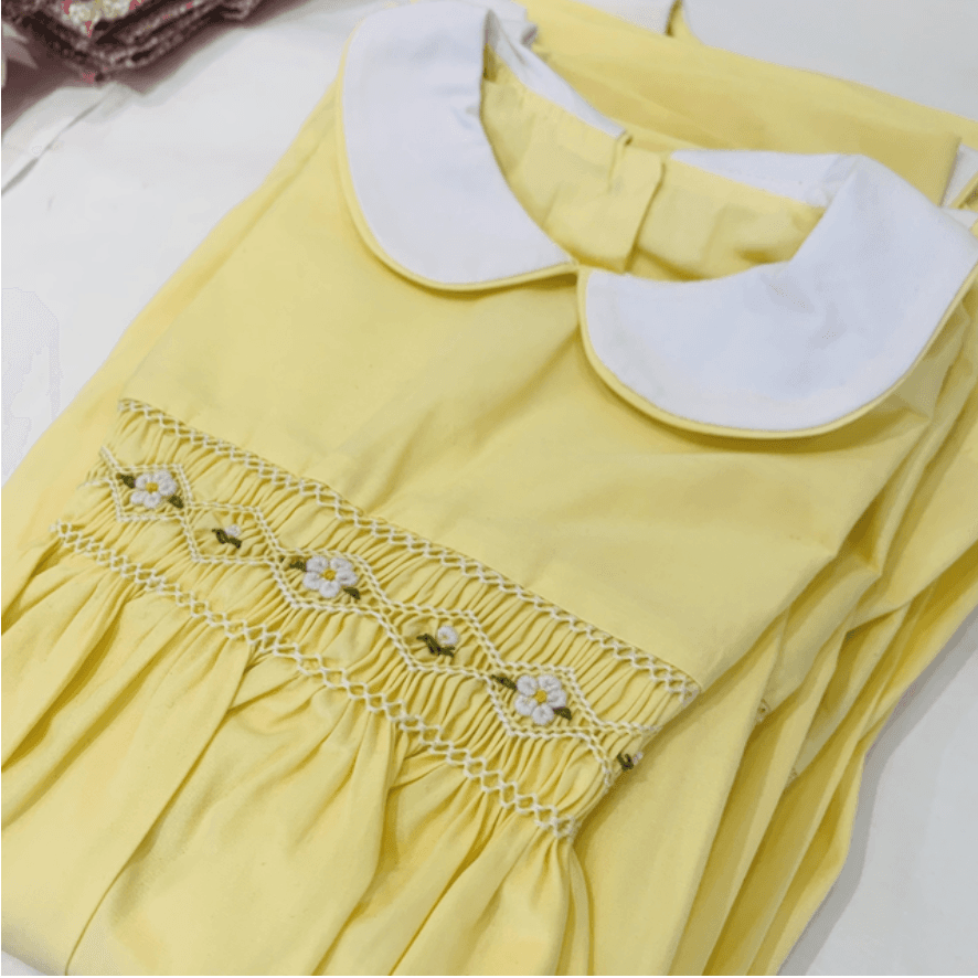 Yellow dress with white Peter Pan collar and smocking featuring small embroidered white flowers.